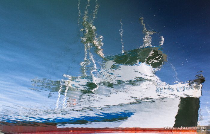 Flipped reflection of a boat in a harbor