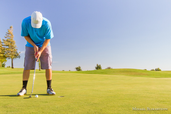 Man playing golf on a sunny day on a beautiful golf course