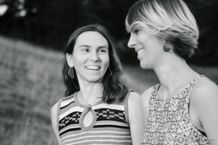 Black and white photo of two young women talking and laughing