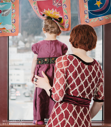 Young mother with her little daughter looking out the window